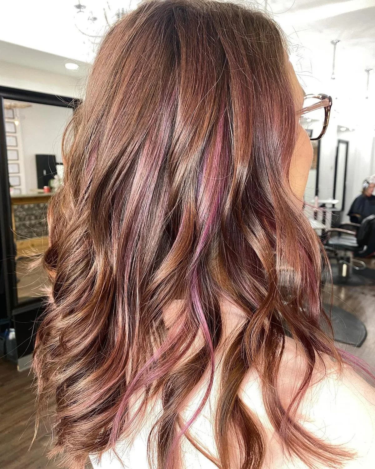 Brunette waves with pink peekaboo color at Dockside Salon in Muskegon, MI