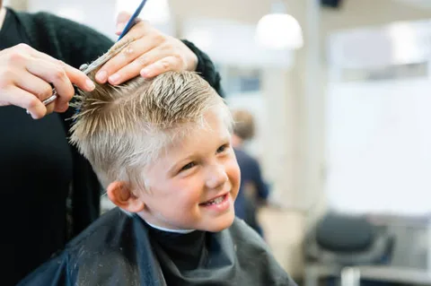 Smiling young boy getting a haircut at Dockside Salon in Muskegon, MI