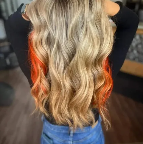 Blonde balayage with orange peekaboo color underneath at Dockside Salon, Muskegon
